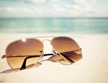 sunglasses in sand on beach