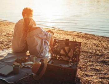 couple having beach picnic at sunset